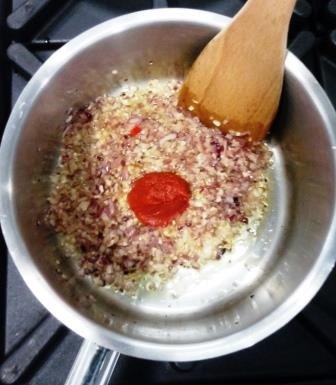 Fry the onion and garlic before adding the tomato paste